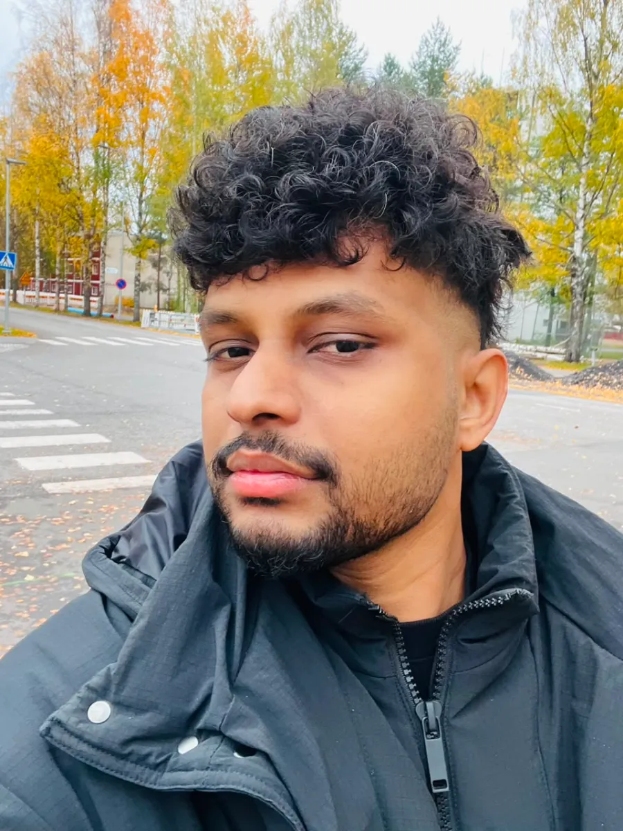 Kavindu Ravishan Perera in a winter jacket on a street lined with yellow autumn birches