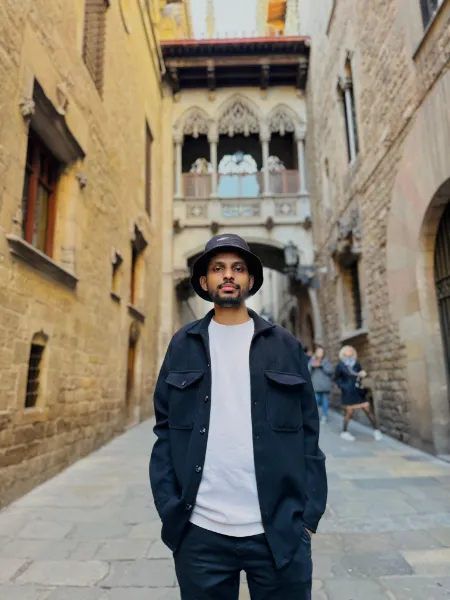 Kavindu Ravishan Perera in Barcelona’s Gothic Quarter, under the carved stone bridge on Carrer del Bisbe