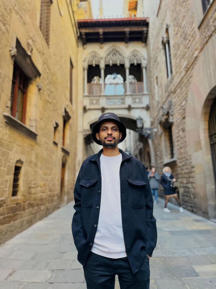 Kavindu Ravishan Perera in Barcelona’s Gothic Quarter, under the carved stone bridge on Carrer del Bisbe
