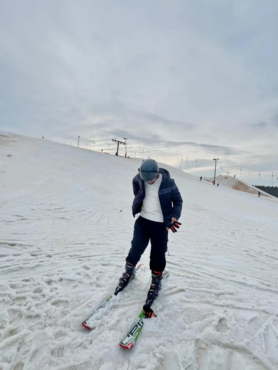 Kavindu Ravishan Perera skiing down a snowy slope under a grey sky