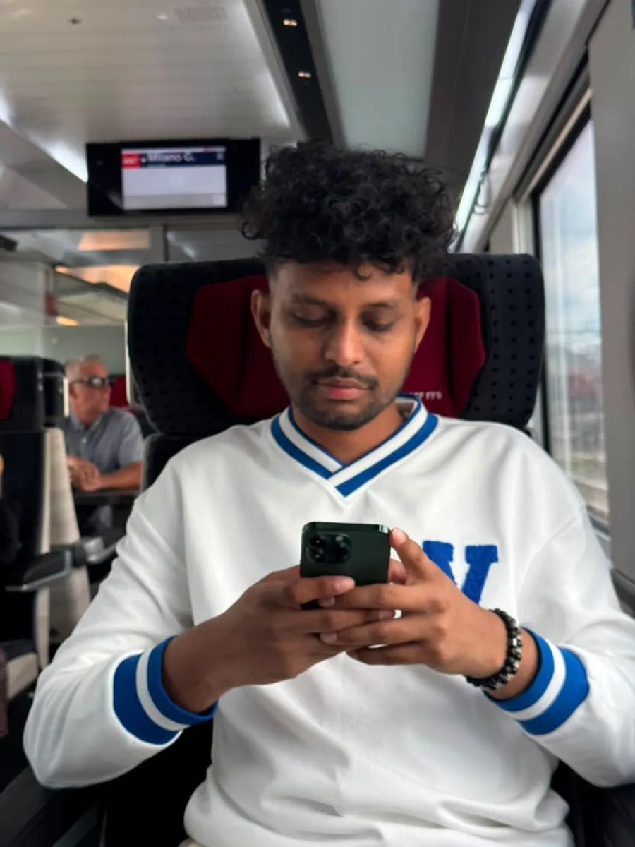 Kavindu Ravishan Perera on a train to Milan, looking at his phone